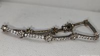 Full view of the silver flower tennis bracelet showing the cubic zirconia stones, flower-shaped accents, and clasp.