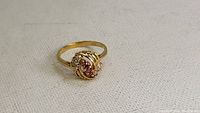 Small gold ring with cluster of pink and clear stones and swirling gold design