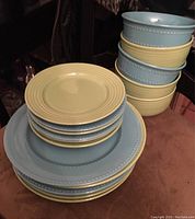 Top view showing stacked blue and lime green dinner plates and bowls.