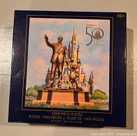 Front view of puzzle box showing Walt Disney and Mickey Mouse statue in front of Cinderella Castle with 50th Anniversary Disney World logo.