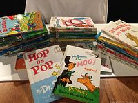 Photo showing stacks of hardcover children's books including Dr. Seuss titles Hop on Pop and Mr. Brown Can Moo! Can You?