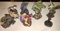Photo showing six resin dragon figurines in various colors and poses placed on a flat surface