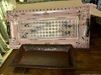 Photo showing both trays stacked, highlighting the perforated design of the larger tray and the embossed floral pattern of the smaller tray.