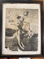 Framed black and white photo of Tex Ritter riding a horse with autograph visible in upper left corner.