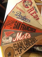 Full view of five vintage baseball pennants for NY Mets, San Francisco Giants, San Diego Padres, LA Dodgers, and Cincinnati Reds, showing condition and design.