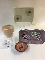 Four ceramic pieces displayed together: small rabbit dish, pink cherry serving tray, rectangular flower vase, and translucent porcelain wine cup.