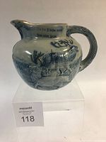 Front angle showing the German inscription and raised elk relief work on the blue salt glaze pitcher.