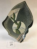 Full view of the leaf-shaped platter with cactus and abstract landscape design showing the overall shape and color pattern.