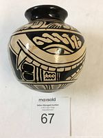 Front and side views of a round Chorotega pottery vase featuring black and beige painted geometric and figurative designs.