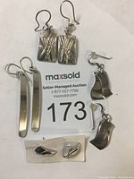 Photo showing all four pairs of sterling silver earrings on a white background with auction card beneath.
