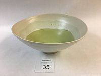 Side perspective of the white/cream stoneware rice bowl with lime green glazed center