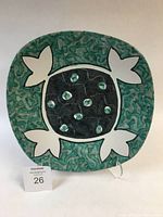 Front view of rectangular majolica charger plate with visible stylized leaf motifs and green-black cream coloring.