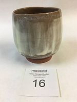 Front view of a Japanese Yunomi tumbler showing the grey and white Ghost Brush glaze and reddish clay exposed at base.