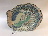 Front and full view of hand painted peacock platter showing shape and color details.