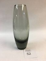 Front view of tall smokey glass vase showing sleek, elongated form with slight taper and gradient smoky coloration.