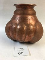 Front angled view of large copper vase showing the lobed geometric design and patina texture