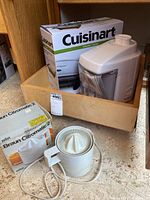 Cuisinart Griddler box with Moulinex juicer on shelf and Braun Citromatic 2 juicer and original box on kitchen counter