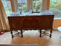 Full front view of wooden buffet with closed doors and drawer
