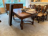 Table assembled, side view with one folded leaf leaning against it