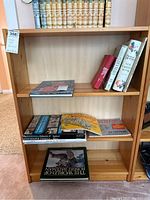 Wooden shelf filled with books and comics, showing three compartments and overall condition.