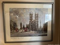 Framed print showing street view of London with Big Ben and Westminster Abbey, including red double-decker buses and pedestrians.