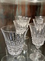 Front side angled view showing multiple crystal champagne glasses with detailed cut patterns on bowls.