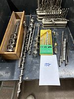 Full lot with drill bits arranged in holders, masonry bits in yellow packaging, and auger bits on the side