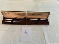 Overview of two Sheaffer Targa pens each in their original presentation box on white fabric background.