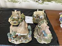 Overview of all 4 Lilliput Lane ceramic cottages showing detailed landscaping and distinct designs.