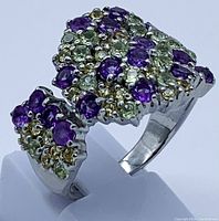 Close-up photo of the ring showing clustered round amethyst, peridot and sapphire stones set in a 925 sterling silver band plated with 14K white gold.