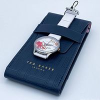 Watch on a navy Ted Baker pouch, showing entire watch and strap with logo visible.