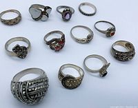 All 12 sterling silver rings arranged on a white background showing different stone types and designs.