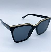 Front angled view showing black square frame sunglasses with gold trim and smoke lenses.