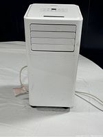 Front view of white Danby portable air conditioner with power cord visible on white backdrop.