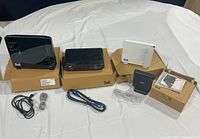 Bell home hub set with three devices and cords arranged on white cloth with their boxes.