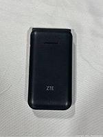 Closed black ZTE textured flip phone from front showing no visible damage.