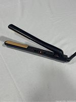 Black CHI Tourmaline Ceramic hairstyling iron shown from an angle with plates partially open, displaying power indicator light and CHI Air logo.