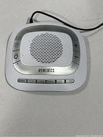 Top view of the sound machine showing speaker grill and control buttons for power, volume, and sound options.