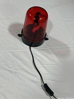 Red LED police light showing unit and cord with switch, dome cover intact and black base with mounting tabs.