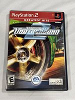 Front cover of the Need for Speed Underground 2 PS2 game case, showing artwork and labels including 'Greatest Hits' and 'EA Games'.