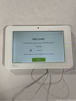 Front view of Qolsys IQ Panel 2 Plus smart home control panel powered on showing welcome installation wizard on touchscreen.