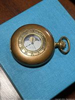 Gold-tone Birks quartz pocket watch with Roman numeral dial and moon phase, showing wear and patina.
