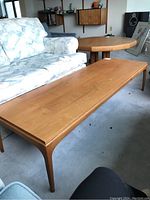 Long rectangular coffee table beside upholstered sofa in living room
