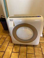 Front view of the Coway air purifier showing the main panel with a circular gray accent.