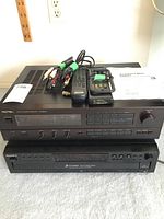 Photo showing the stacked Sony CD player CDP-CE375 and Rotel RX-950AX stereo receiver with remotes, cables, and manuals on top.