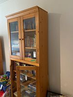 Full view of the pine wood bookcase with upper and lower glass doors, showing overall structure and wood finish.