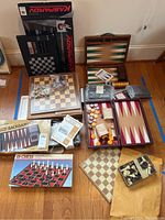 Full view of chess and backgammon sets, including boards, pieces in bags, electronic chess computer box.