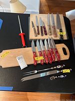 Full overview of cutlery, sharpener and cutting boards on black surface