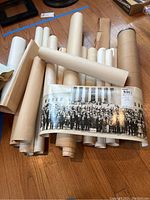 Collection of rolled maps and a vintage black and white photo with a large group in front of columns.
