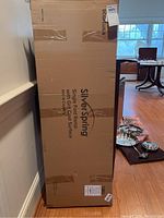 Photo of boxed Silver Spring single fold ramp standing upright against a wall.